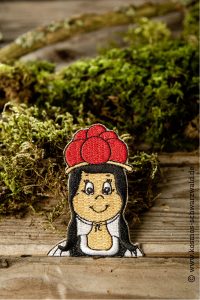 Der Sticker von Anni zeigt das Schwarzwaldmädchen bis zur Brust und liegt auf einem Stück Holz mit Moos im Hintergrund